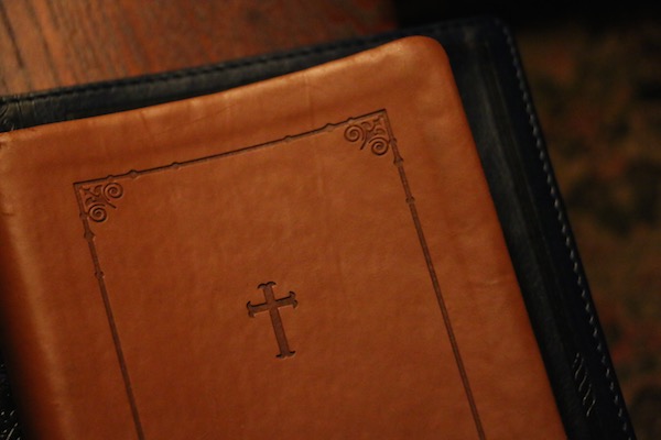 Leather-bound Bible on a wooden church pew