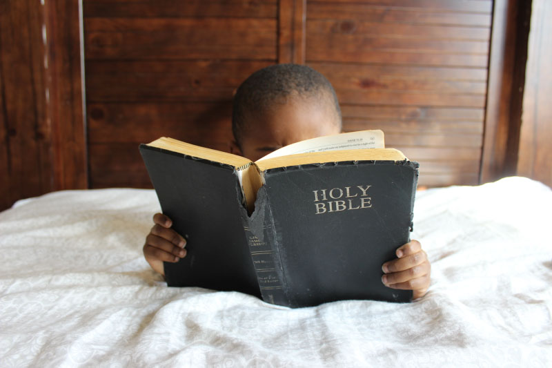 Little boy reading the Bible